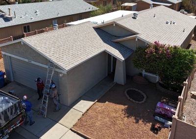 A group of people on a ladder in front of a house.